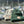 Green Cream and Gray boat beanies are displayed out in front of a boat harbor in Juneau